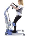 Disposable sit to stand sling by Joerns Hoyer supporting a patient on a Hoyer stand aid lift