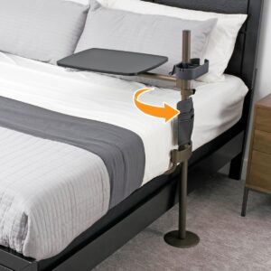 Stander Freedom swivel overbed table attached to the side of a bed with black tray and champagne gold post