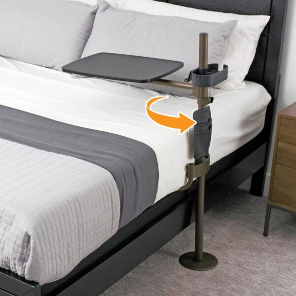 Stander Freedom swivel overbed table attached to the side of a bed with black tray and champagne gold post