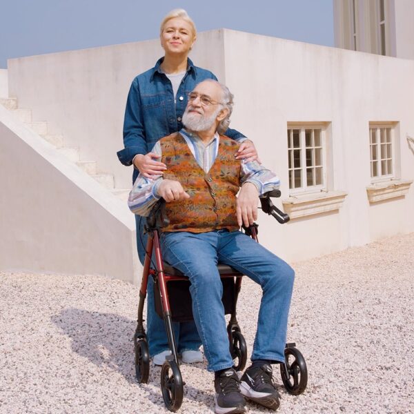 Senior man seated on a parked red VOCIC Z21 rollator