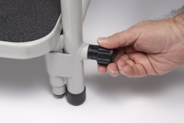Adjusting the hip chair footrest height by pulling the knob