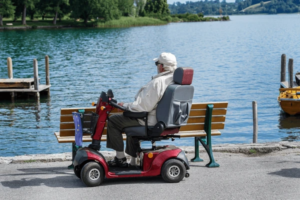 Elderly senior enjoying a beautiful day outdoors with his mobility scooter, highlighting the freedom and independence that mobility aids for seniors provide.