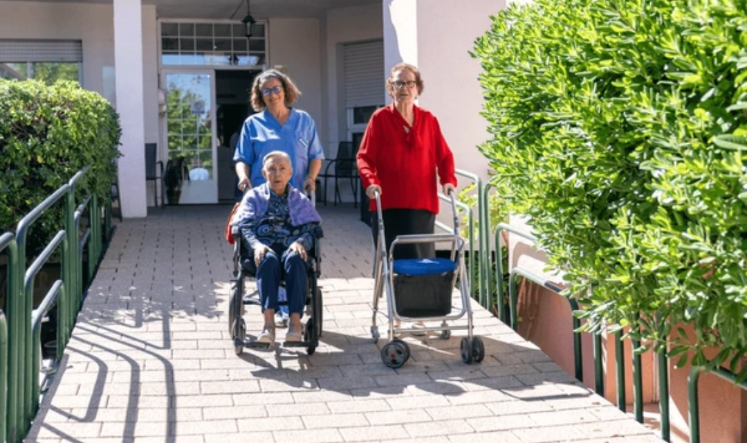 Seniors using rolling walkers outdoors, demonstrating the benefits of mobility aids for seniors in maintaining independence and stability.