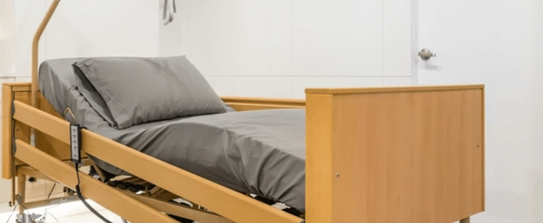 Senior getting up safely from an ultra-low adjustable hospital bed — best bed for elderly at home with caregiver assist