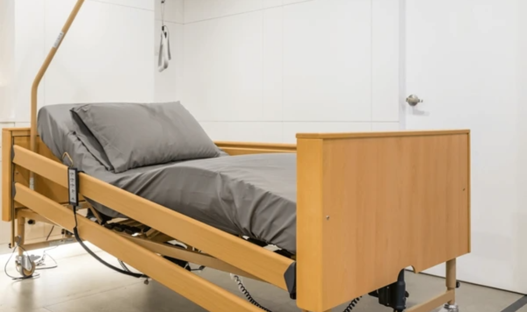 Senior getting up safely from an ultra-low adjustable hospital bed — best bed for elderly at home with caregiver assist
